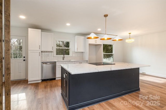 kitchen with stainless steel dishwasher, decorative light fixtures, a center island, and white cabinets