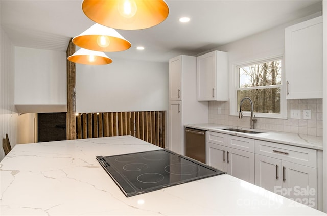 kitchen with decorative light fixtures, white cabinetry, sink, stainless steel dishwasher, and light stone counters