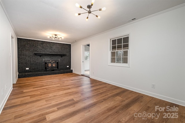 unfurnished living room featuring crown molding, hardwood / wood-style floors, and a notable chandelier