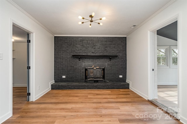 unfurnished living room featuring an inviting chandelier, ornamental molding, light hardwood / wood-style floors, and a wood stove