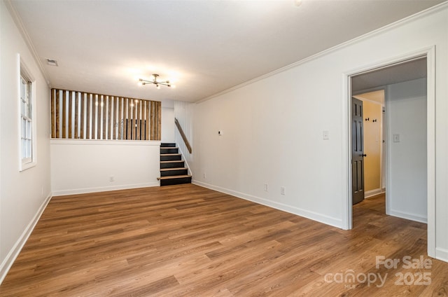 spare room with crown molding and wood-type flooring