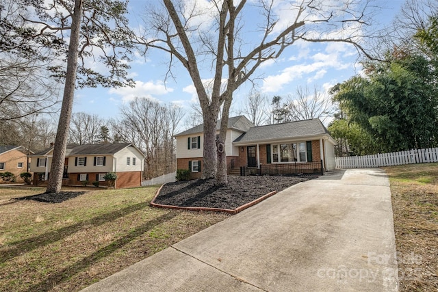 split level home featuring a porch and a front lawn