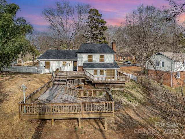 back house at dusk with a deck