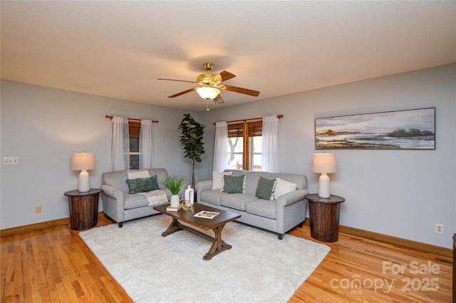 living room with hardwood / wood-style floors, a textured ceiling, and ceiling fan