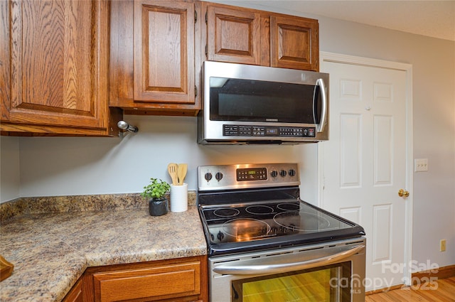 kitchen with appliances with stainless steel finishes and light stone counters