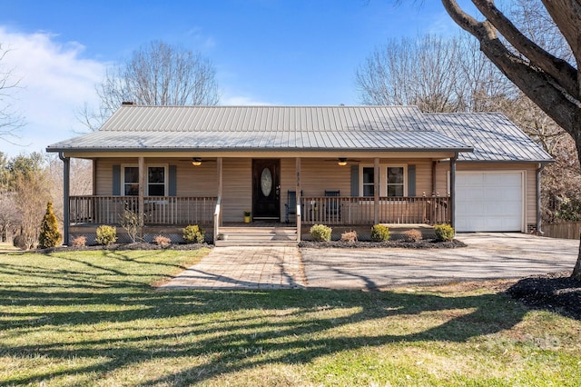 view of front of house featuring a garage, covered porch, metal roof, and a front yard