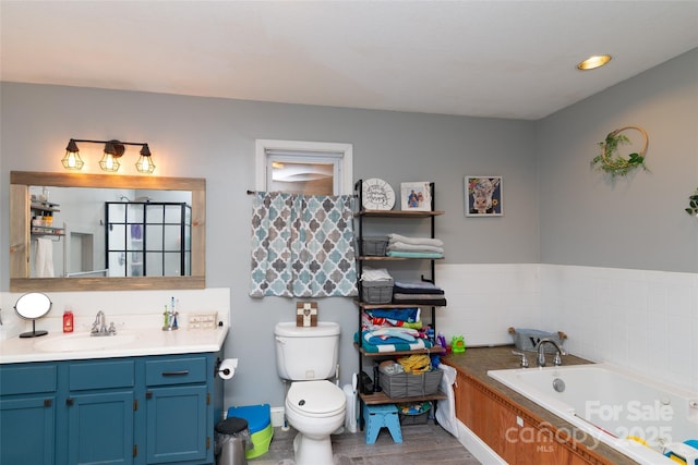 bathroom with vanity, a bath, hardwood / wood-style floors, and toilet