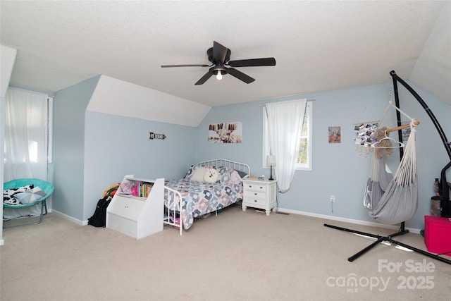 bedroom featuring lofted ceiling, ceiling fan, a textured ceiling, and carpet