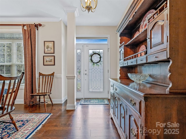 foyer with dark hardwood / wood-style flooring, crown molding, a healthy amount of sunlight, and ornate columns