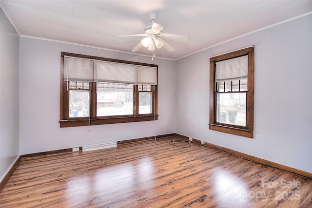 empty room with hardwood / wood-style flooring, ornamental molding, and ceiling fan