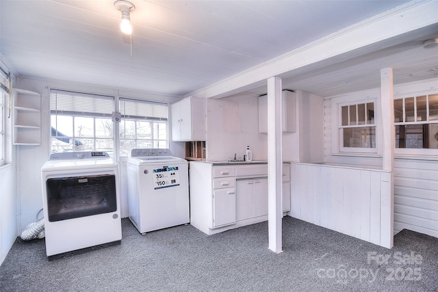 kitchen featuring white cabinetry, separate washer and dryer, dark colored carpet, and wood walls