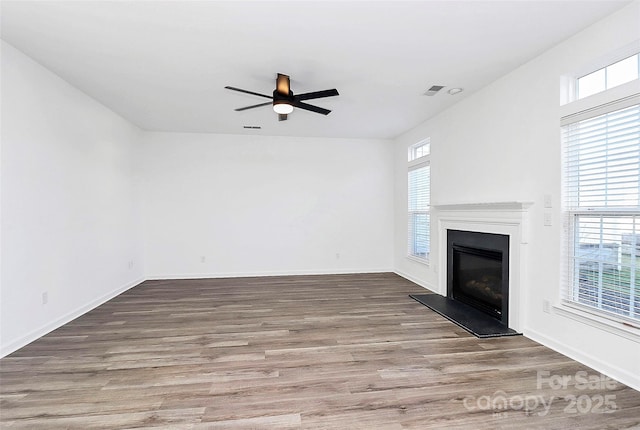 unfurnished living room featuring ceiling fan and hardwood / wood-style floors