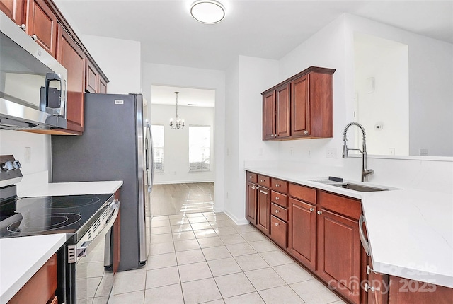 kitchen with sink, light tile patterned floors, appliances with stainless steel finishes, decorative light fixtures, and a chandelier