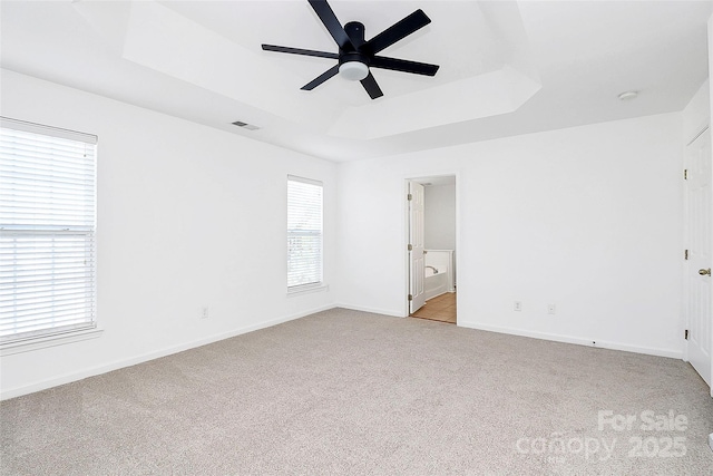 interior space with a raised ceiling and ceiling fan