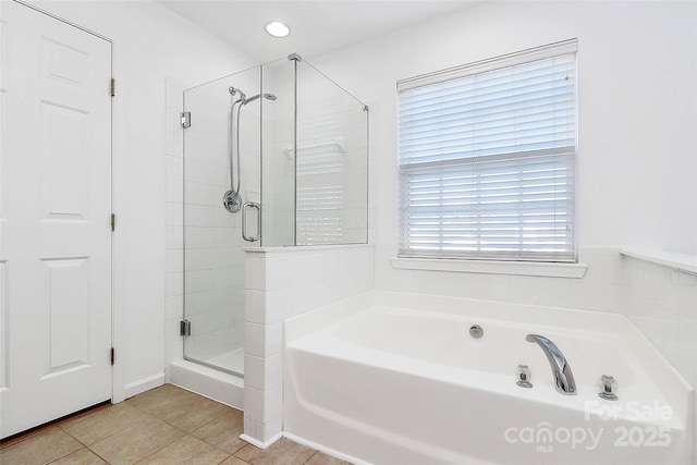 bathroom featuring tile patterned flooring and shower with separate bathtub