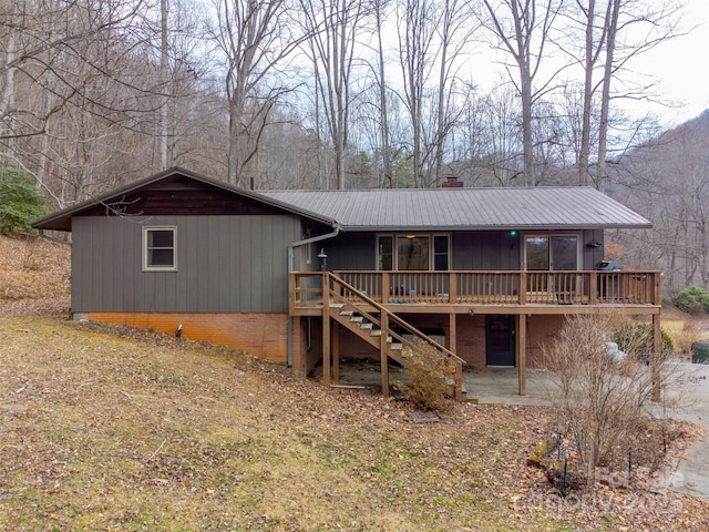 rear view of house featuring a wooden deck