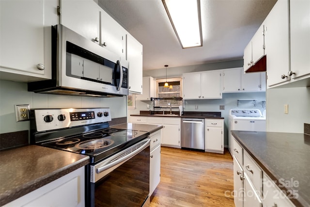 kitchen with sink, white cabinetry, decorative light fixtures, light wood-type flooring, and stainless steel appliances