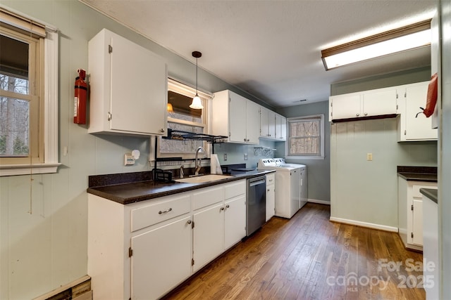 kitchen with white cabinetry, separate washer and dryer, sink, and stainless steel dishwasher