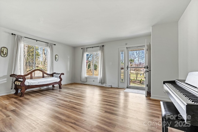 sitting room with hardwood / wood-style flooring and a healthy amount of sunlight