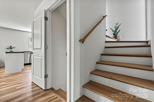 stairs featuring hardwood / wood-style floors