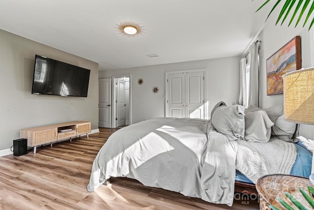 bedroom with hardwood / wood-style floors and a closet