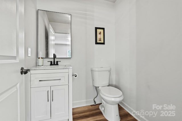 bathroom featuring vanity, toilet, and hardwood / wood-style floors