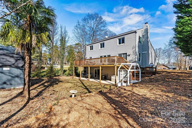 back of house with a wooden deck and a patio area