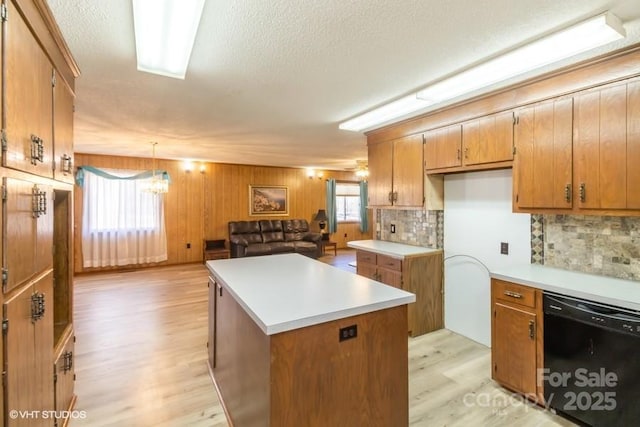 kitchen featuring a center island, light hardwood / wood-style flooring, dishwasher, pendant lighting, and a healthy amount of sunlight