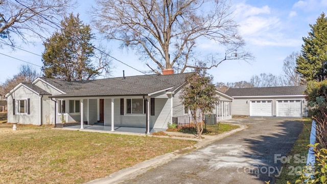 ranch-style home featuring a garage, a porch, central air condition unit, and a front lawn