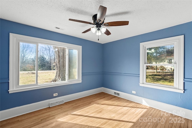 empty room with ceiling fan, light hardwood / wood-style floors, and a textured ceiling