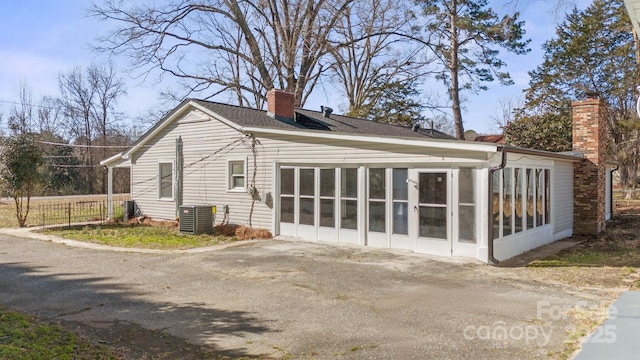 back of property with a sunroom and cooling unit