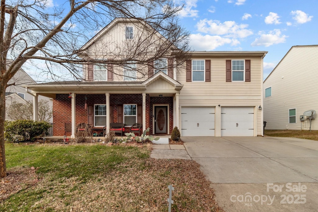 view of front property featuring a garage, a front lawn, and covered porch