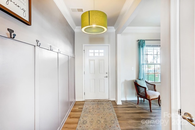 foyer featuring ornamental molding, baseboards, visible vents, and light wood finished floors