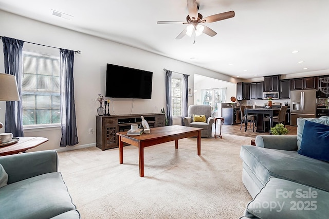 living room with light carpet, baseboards, visible vents, a ceiling fan, and recessed lighting