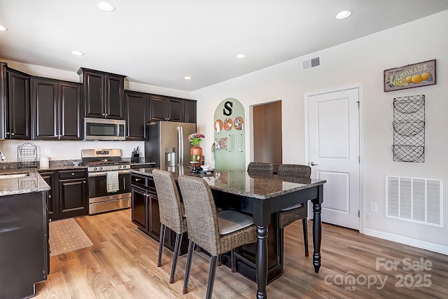 kitchen featuring light wood-type flooring, visible vents, appliances with stainless steel finishes, and a sink