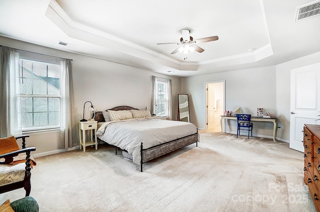 bedroom with light colored carpet, a raised ceiling, visible vents, and baseboards