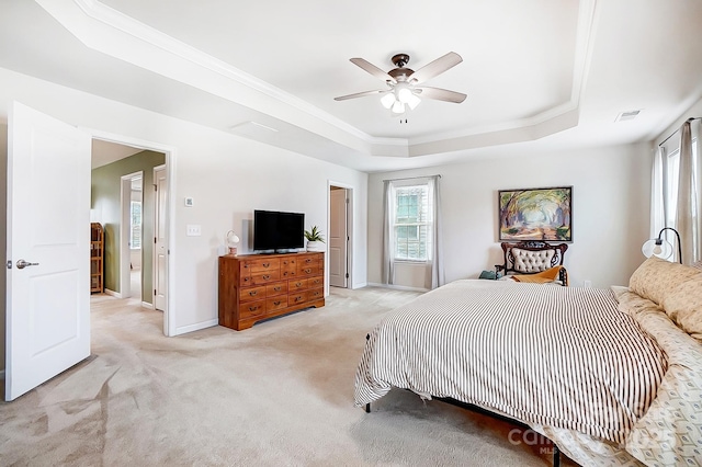 bedroom featuring baseboards, visible vents, light colored carpet, ornamental molding, and a tray ceiling