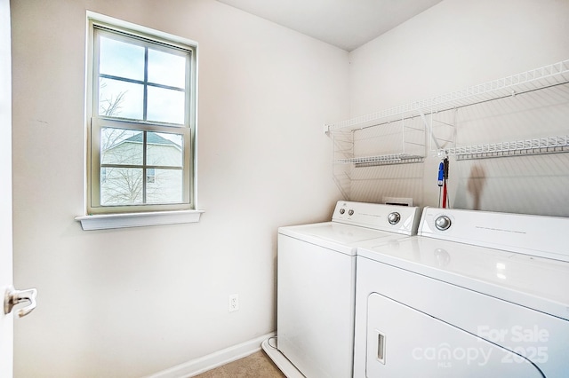 laundry area with laundry area, washing machine and clothes dryer, and baseboards