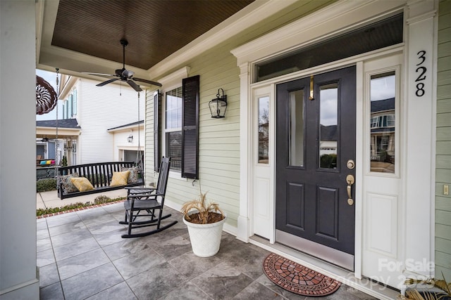 entrance to property featuring a porch and ceiling fan