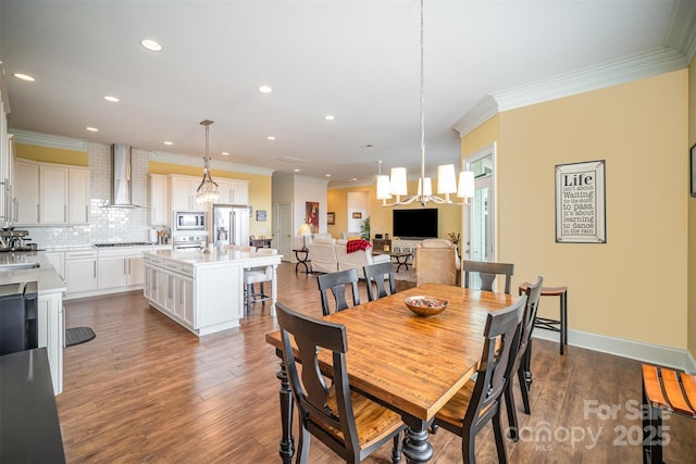 dining area featuring an inviting chandelier, ornamental molding, dark hardwood / wood-style floors, and sink