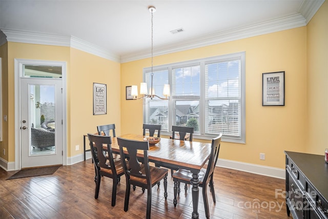 dining area with dark hardwood / wood-style flooring, a notable chandelier, and crown molding