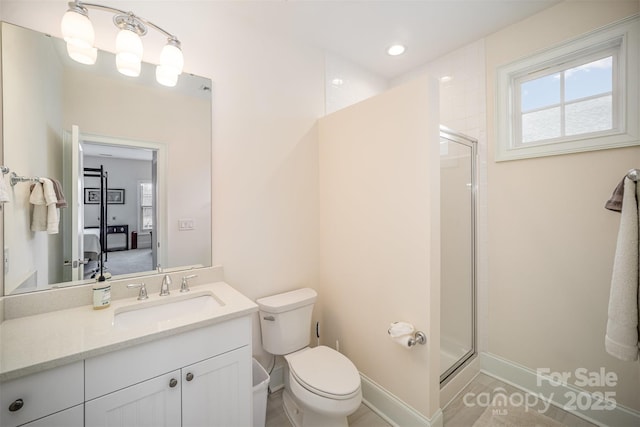 bathroom featuring vanity, a shower with shower door, and toilet