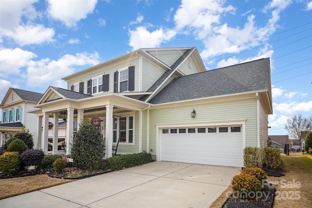 view of front of home with a garage, driveway, and a shingled roof