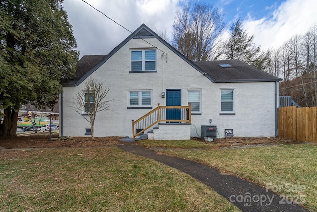 rear view of property featuring cooling unit and a lawn