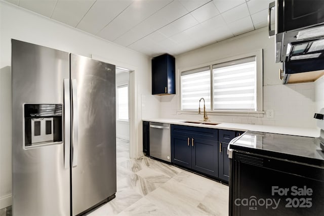 kitchen with tasteful backsplash, sink, stainless steel appliances, and blue cabinetry