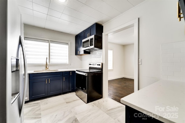 kitchen with sink, a wealth of natural light, stainless steel appliances, and blue cabinets