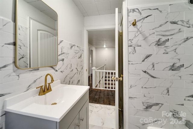 bathroom with vanity and tile walls