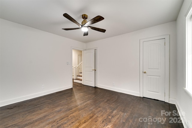 empty room with ceiling fan and dark hardwood / wood-style flooring