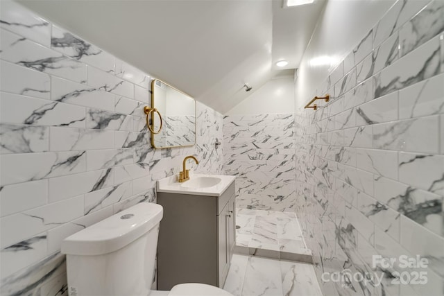 bathroom featuring tile walls, vanity, and toilet