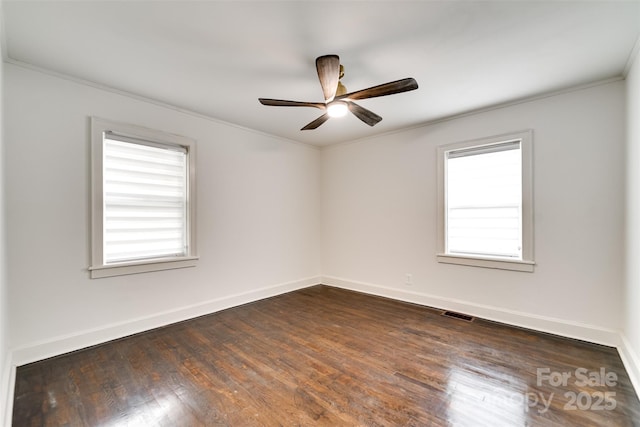 unfurnished room featuring crown molding, a healthy amount of sunlight, dark wood-type flooring, and ceiling fan